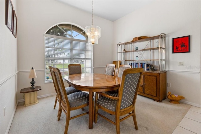 dining room featuring a chandelier, light tile patterned floors, light colored carpet, and baseboards