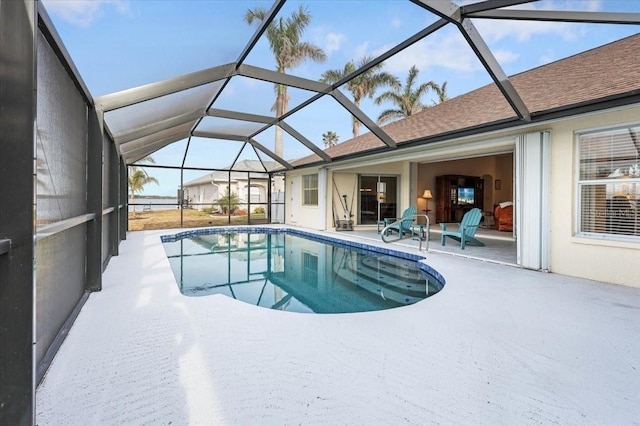 outdoor pool with glass enclosure and a patio