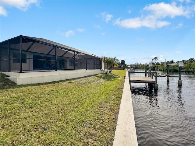 view of dock with a lanai and a lawn