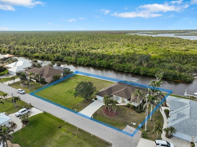 drone / aerial view featuring a forest view and a water view