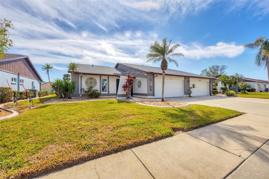 ranch-style home with a garage and a front lawn