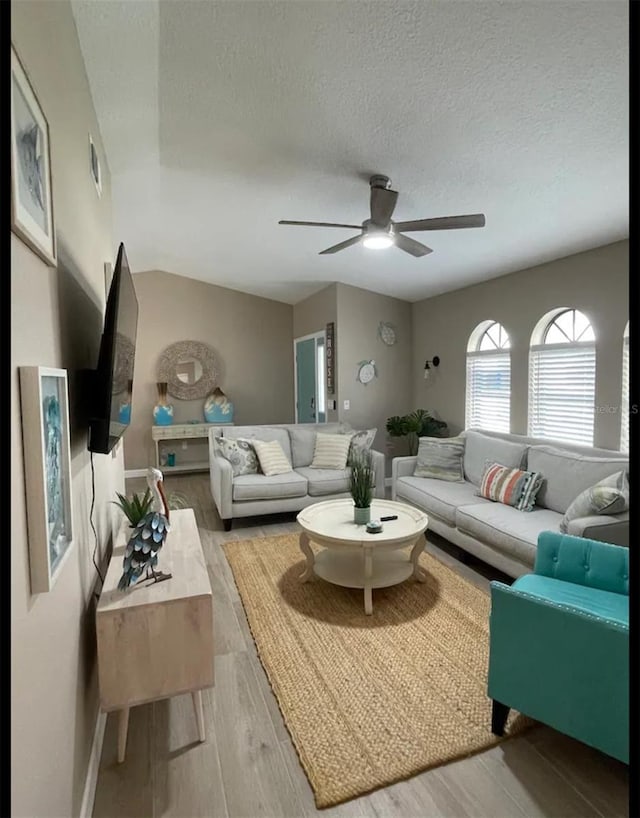 living room with wood-type flooring, a textured ceiling, and ceiling fan