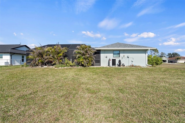 back of house with cooling unit, glass enclosure, and a lawn