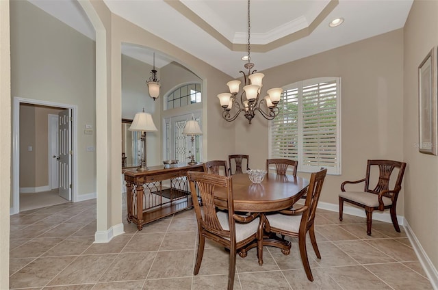 dining space featuring a chandelier, crown molding, a raised ceiling, and light tile patterned floors