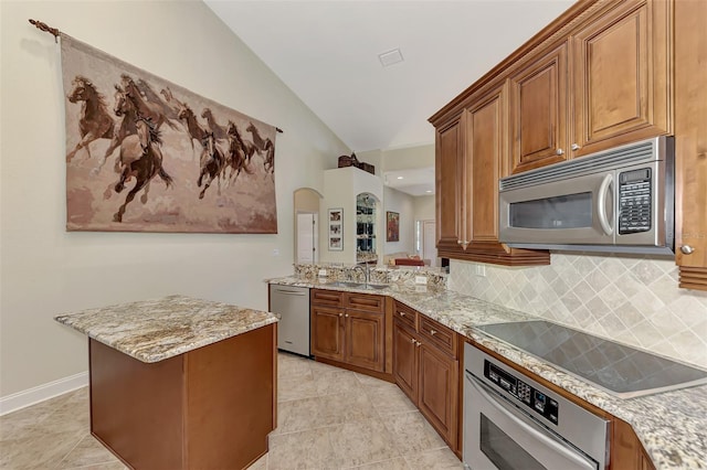 kitchen with sink, appliances with stainless steel finishes, tasteful backsplash, light stone countertops, and vaulted ceiling