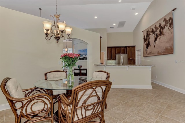 dining area with high vaulted ceiling, light tile patterned floors, and a chandelier