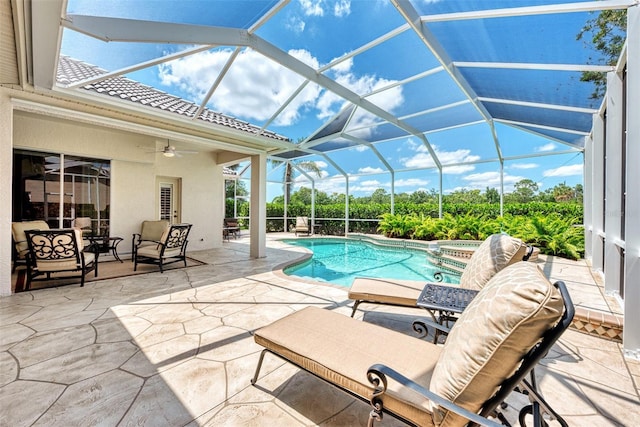 view of swimming pool featuring a lanai, a patio, ceiling fan, and an in ground hot tub