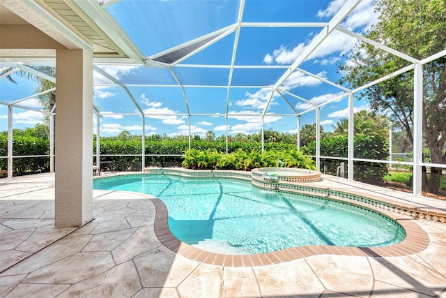 view of swimming pool featuring an in ground hot tub, a lanai, and a patio