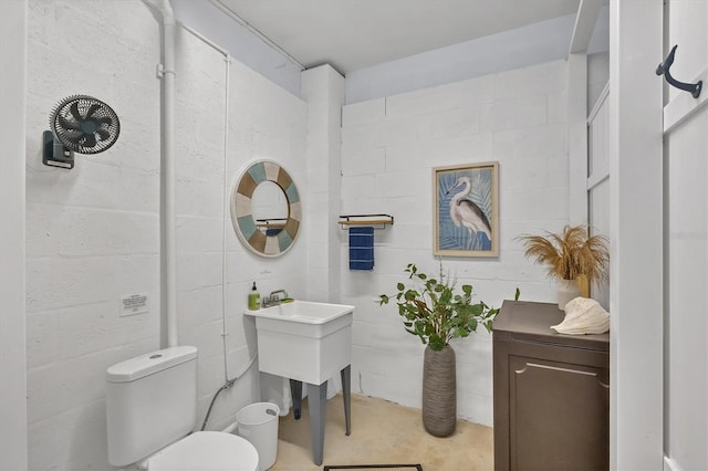 bathroom featuring concrete flooring and toilet