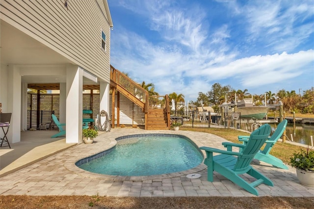 view of swimming pool featuring a water view and a patio area