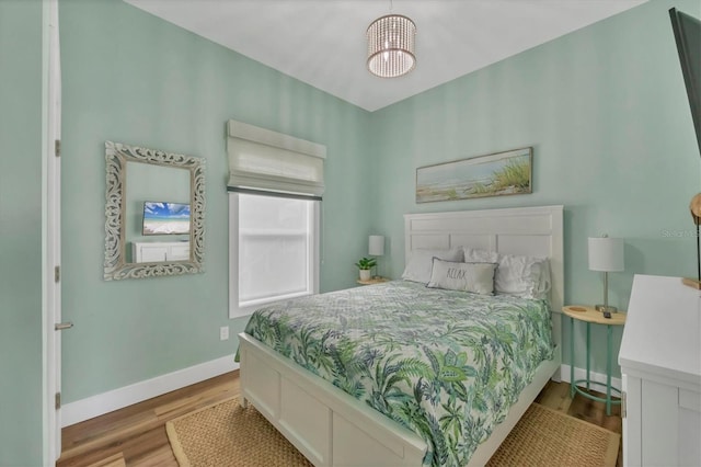 bedroom featuring light hardwood / wood-style flooring and a notable chandelier