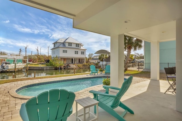 view of swimming pool with a water view and a patio area