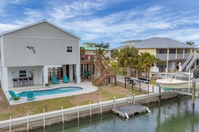 back of property featuring a fenced in pool, a patio, a water view, and an outdoor bar