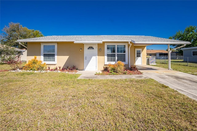 view of front of home with stucco siding, fence, a carport, driveway, and a front lawn