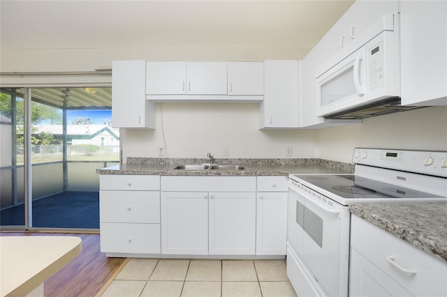 kitchen featuring light tile patterned floors, white appliances, a sink, white cabinets, and light countertops