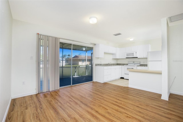 kitchen featuring white appliances, light wood finished floors, visible vents, white cabinets, and light countertops