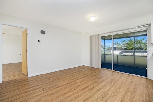 spare room with light wood-type flooring and baseboards