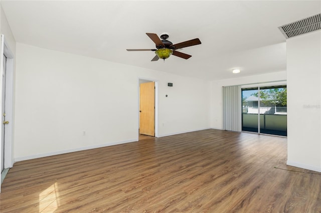 spare room featuring a ceiling fan, wood finished floors, visible vents, and baseboards