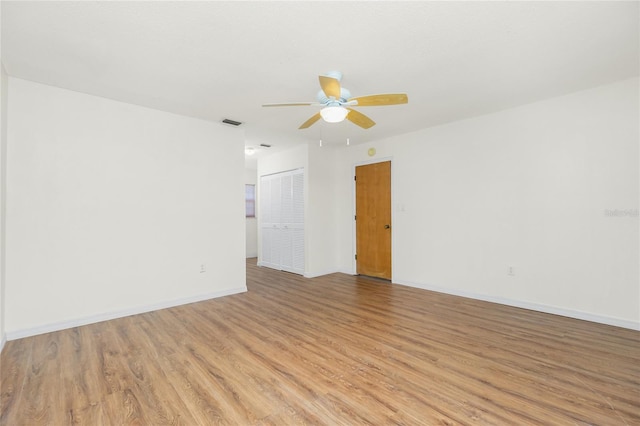 unfurnished room with baseboards, visible vents, ceiling fan, and light wood finished floors