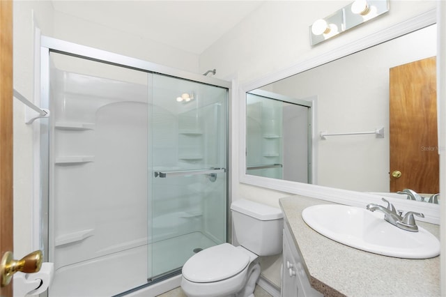 bathroom featuring a shower stall, toilet, and vanity