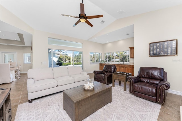 living room featuring lofted ceiling, ceiling fan, and light tile patterned flooring