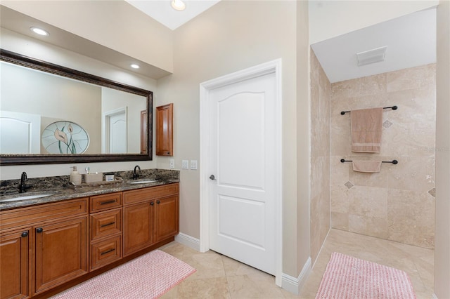 bathroom featuring vanity, tile patterned floors, and tiled shower