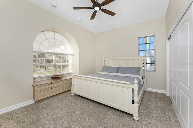 bedroom with ceiling fan, carpet floors, and a closet