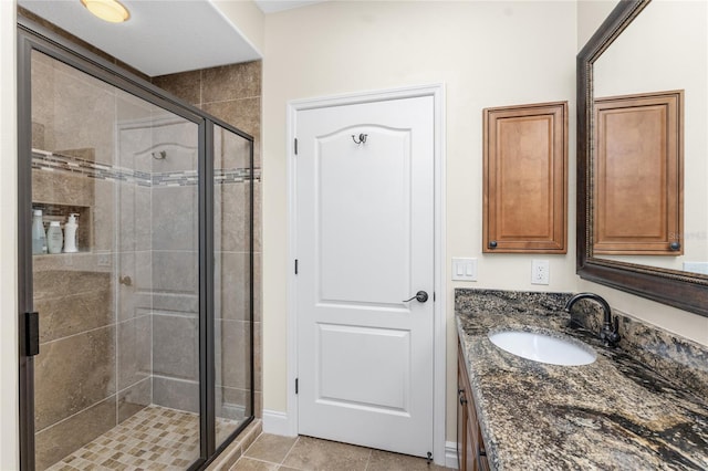 bathroom featuring tile patterned floors, vanity, and a shower with shower door