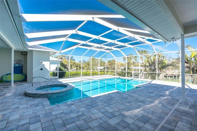 view of swimming pool with an in ground hot tub, glass enclosure, and a patio