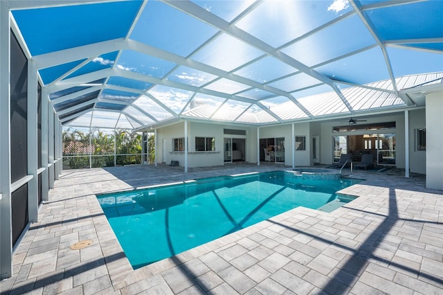 view of pool featuring ceiling fan, an in ground hot tub, glass enclosure, and a patio