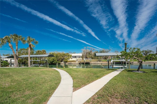 view of home's community with a water view and a lawn