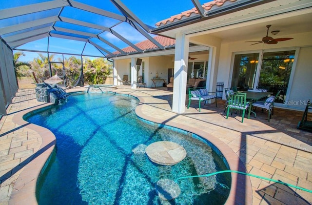 view of pool with a lanai, a patio, ceiling fan, and an in ground hot tub