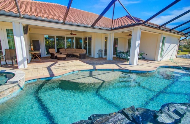 view of swimming pool with a lanai, ceiling fan, outdoor lounge area, a patio, and an in ground hot tub