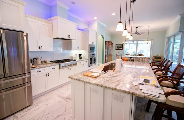 kitchen with a kitchen island with sink, a breakfast bar, and appliances with stainless steel finishes