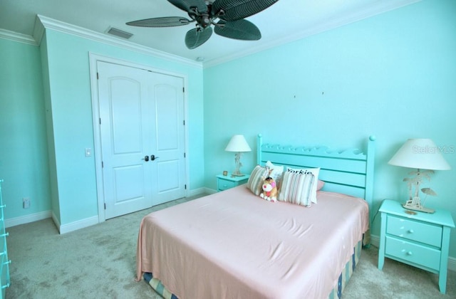 bedroom featuring crown molding, light colored carpet, ceiling fan, and a closet