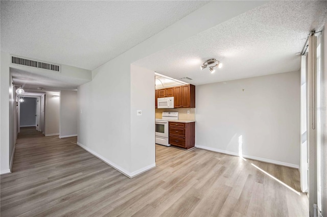 unfurnished living room featuring light hardwood / wood-style floors and a textured ceiling