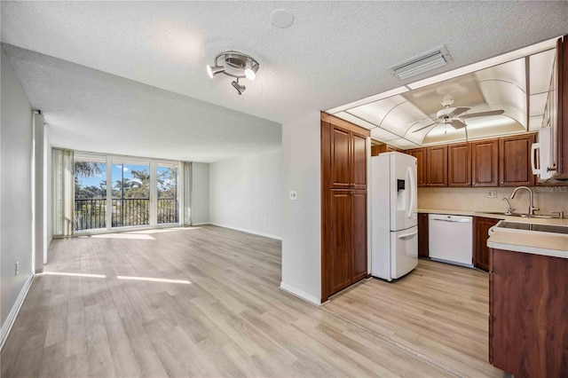 kitchen featuring sink, white appliances, ceiling fan, a textured ceiling, and light hardwood / wood-style flooring