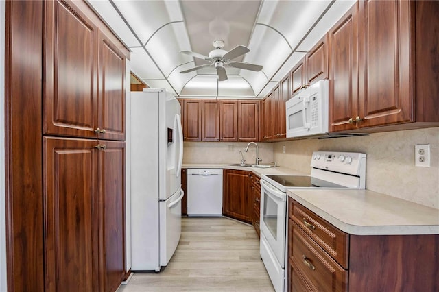 kitchen with sink, white appliances, ceiling fan, and light wood-type flooring