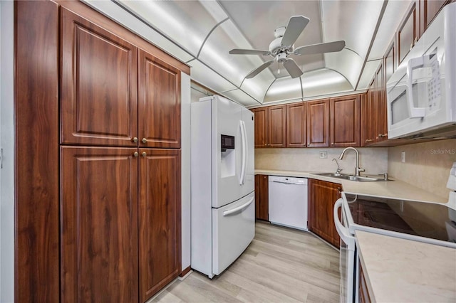 kitchen featuring sink, light wood-type flooring, decorative backsplash, ceiling fan, and white appliances