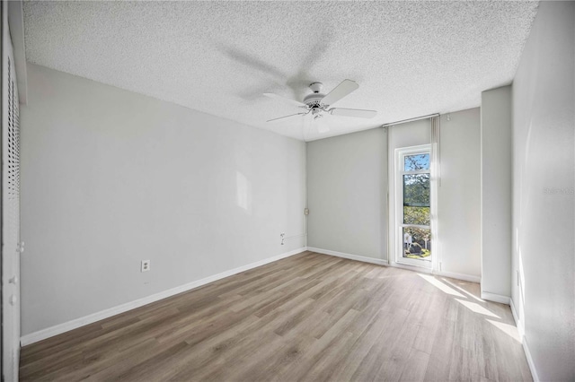 empty room featuring ceiling fan, light hardwood / wood-style floors, and a textured ceiling