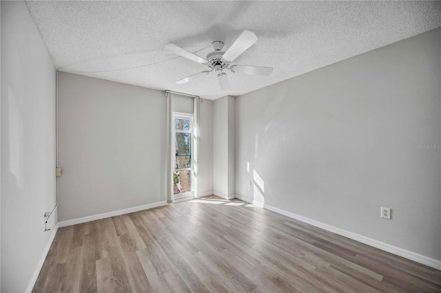 spare room with ceiling fan, light hardwood / wood-style flooring, and a textured ceiling