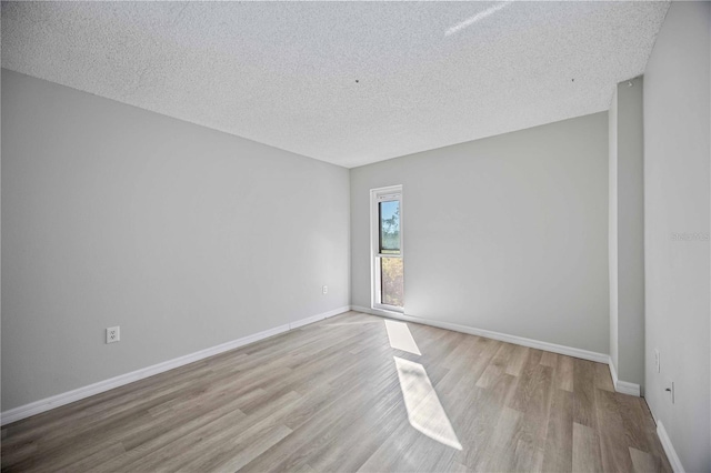 unfurnished room featuring a textured ceiling and light wood-type flooring