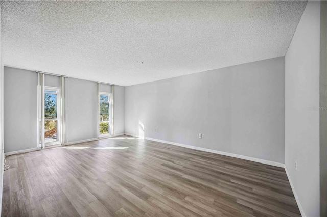 spare room featuring hardwood / wood-style floors and a textured ceiling