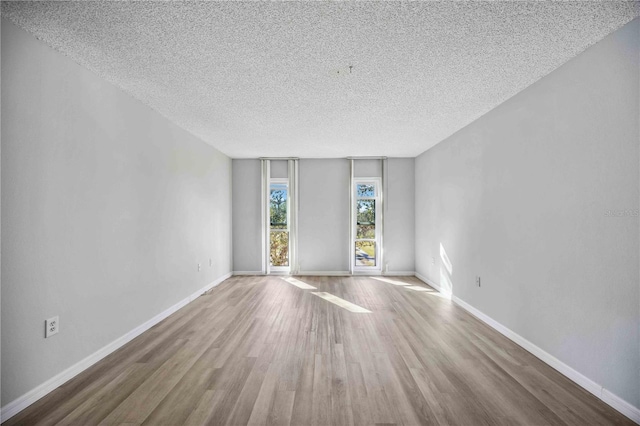 spare room featuring hardwood / wood-style flooring and a textured ceiling