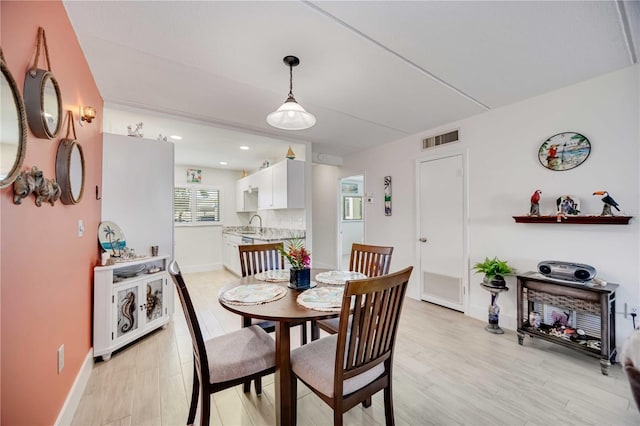 dining room with sink and light wood-type flooring