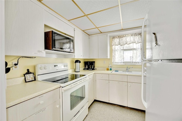 kitchen with white cabinetry, sink, and white appliances