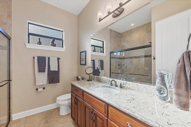 bathroom with vanity, tile patterned flooring, toilet, and walk in shower