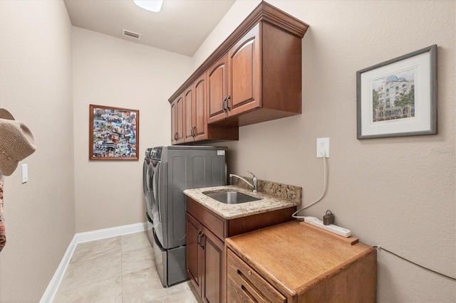 laundry room with cabinets, sink, light tile patterned floors, and independent washer and dryer