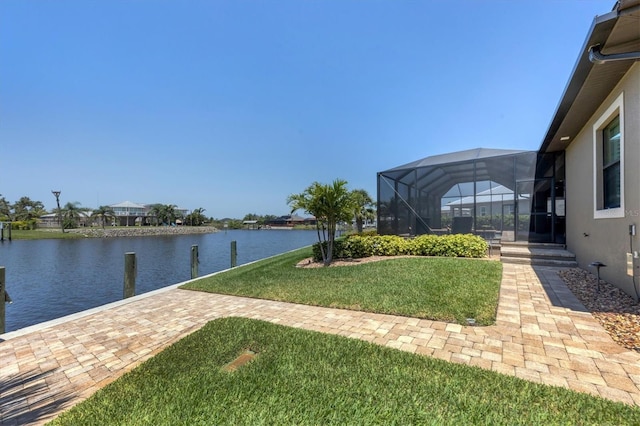 view of yard with a water view, glass enclosure, and a boat dock