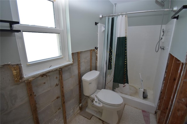 bathroom featuring toilet and curtained shower